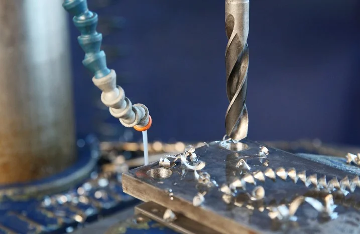 Metallbohrer bohrt Loch in Metallplatte